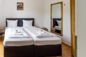 duże łóżko w pokoju z lustrem w obiekcie Ferienhaus Mosellage w mieście Zell an der Mosel