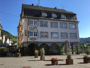 a large white building with windows on a street at Mosel Ferienhaus Zell in Zell an der Mosel