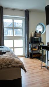 een slaapkamer met een bed en een groot raam bij Industrialdesign Düren in Düren - Eifel