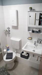 a white bathroom with a toilet and a sink at Industrialdesign Düren in Düren - Eifel