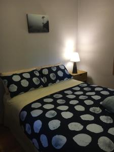 ein Schlafzimmer mit einem Bett mit einer schwarzen und weißen Decke in der Unterkunft The Shack in Southport