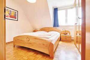 ein Schlafzimmer mit einem Holzbett und einem Fenster in der Unterkunft Ferienhaus Achtern Feeld in Hüde