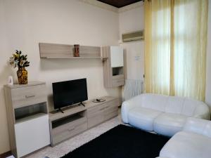 a living room with a white couch and a television at Henson appartamento in Tortona