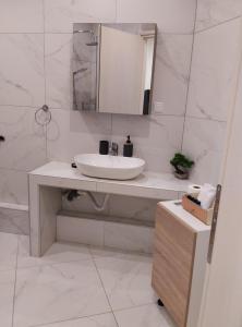 a white bathroom with a sink and a mirror at Domus Apartment - City Center in Veria