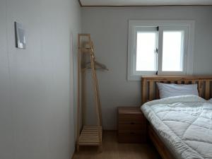 a bedroom with a bed and a ladder next to a window at Clara House in Seoul