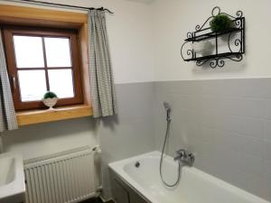 een badkamer met een bad en een raam bij Ferienwohnung zum Gimpei in Siegsdorf