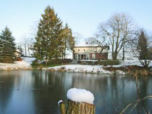 ein Haus mit Schnee auf einem See in der Unterkunft Ferienhaus NATURlich Wassermuhle in Kappeln