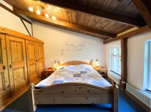 カッペルンにあるFerienhaus NATURlich Wassermuhleのベッドルーム1室(壁に看板のある木製ベッド1台付)