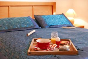 a tray with a cup of coffee on a bed at Apartments Kirsebek in Kappeln