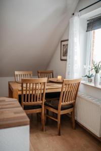 a dining room with a wooden table and chairs at Apartments Kirsebek in Kappeln