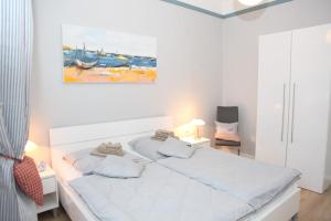 a white bedroom with a bed and a painting on the wall at Amanda in Kappeln