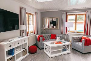 a living room with two chairs and a tv at Ferienhaus Kleiner Onkel in Grödersby