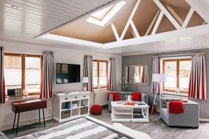 a living room with a couch and a tv at Ferienhaus Kleiner Onkel in Grödersby +18 photos