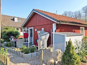 a red house with a garden in front of it at Ferienhaus Kleiner Onkel in Grödersby