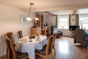 a dining room and living room with a table and chairs at Amrum in Kappeln