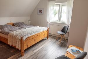 a bedroom with a bed and a chair and a window at Amrum in Kappeln