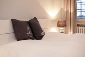a bedroom with a bed with black pillows and a lamp at Seestern in Kappeln