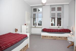 a bedroom with two beds and two windows at Seestern in Kappeln