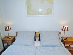 a bed with two lamps and a map on the wall at Lohdiele in Kappeln
