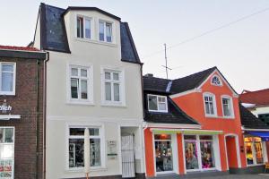 a white and orange building on a street at Lohdiele in Kappeln