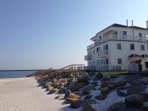 a large white building on the beach next to the water at The Sea Room in Olpenitz