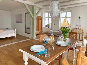 una sala de estar con una mesa de madera con platos. en Speicherloft, en Kappeln