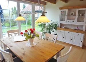 a kitchen with a wooden table with flowers on it at Rosenhaus in Kappeln