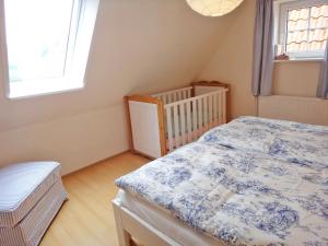 ein kleines Schlafzimmer mit einem Bett und einem Kinderbett in der Unterkunft Rosenhaus in Kappeln