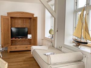 a living room with a tv and a boat in a window at Speicherloft in Kappeln