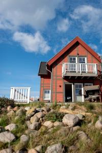 a house on the beach with rocks in front of it at Hus im Lee un Luv in Olpenitz