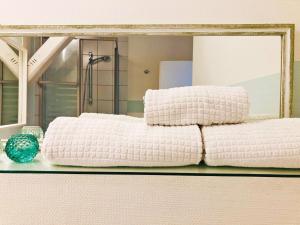 una pila de almohadas blancas en un estante frente a un espejo en Speicherkoje en Kappeln