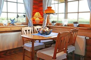 a dining room with a table and chairs and windows at Mein Blockhaus in Hasselberg