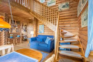 a living room with a blue couch and stairs in a log cabin at Mein Blockhaus in Hasselberg