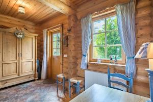 a dining room with a table and chairs and a window at Mein Blockhaus in Hasselberg +21 photos