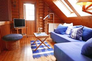 a living room with a blue couch and a tv at Mein Blockhaus in Hasselberg