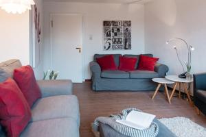 a living room with a couch and red pillows at Altes Kapitänshaus in Arnis