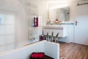 ein weißes Badezimmer mit einer Badewanne und einem Waschbecken in der Unterkunft Altes Kapitänshaus in Arnis