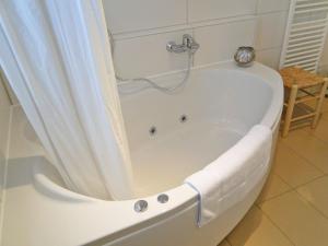 a white bath tub with a shower curtain in a bathroom at The Beach House in Olpenitz