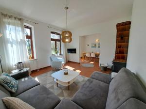 a living room with a couch and a table at Naturnahes Ostsee und Schlei Erlebnis im Landhaus Grüne Oase an der Geltinger Bucht in Stangheck