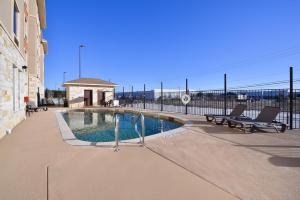 a swimming pool with a bench next to a building at Sleep Inn & Suites Austin – Tech Center in Austin