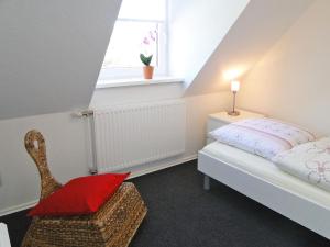 a bedroom with a bed and a chair and a window at Skrey's To Hus in Kappeln