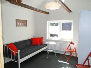 a living room with a couch and red pillows at Skrey's To Hus in Kappeln