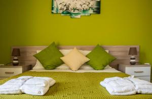 a green bedroom with a bed with towels on it at Blu Mare Lampedusa Bed And Breakfast in Lampedusa