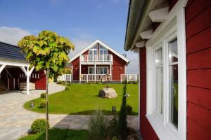 a red house with a tree in the yard at Thor's Schleilounge in Olpenitz