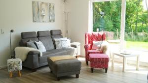 a living room with a couch and two chairs at Schmidt's Huus in Damp