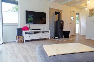 a living room with a fireplace and a tv at Schmidt's Huus in Damp