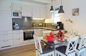 Una cocina con una mesa y sillas en una cocina. en Schmidt's Huus, en Damp 11 fotos más