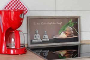 a red blender sitting on a counter next to a picture at Dornröschen in Brarupholz +8 photos
