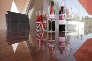 tres botellas de vino y copas en una mesa de cristal en Zum Kuhfleck en Damp