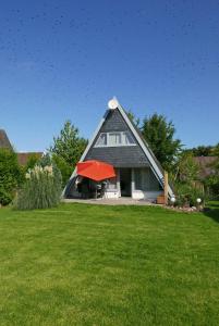 una casa con un paraguas rojo en un patio en Zum Kuhfleck en Damp